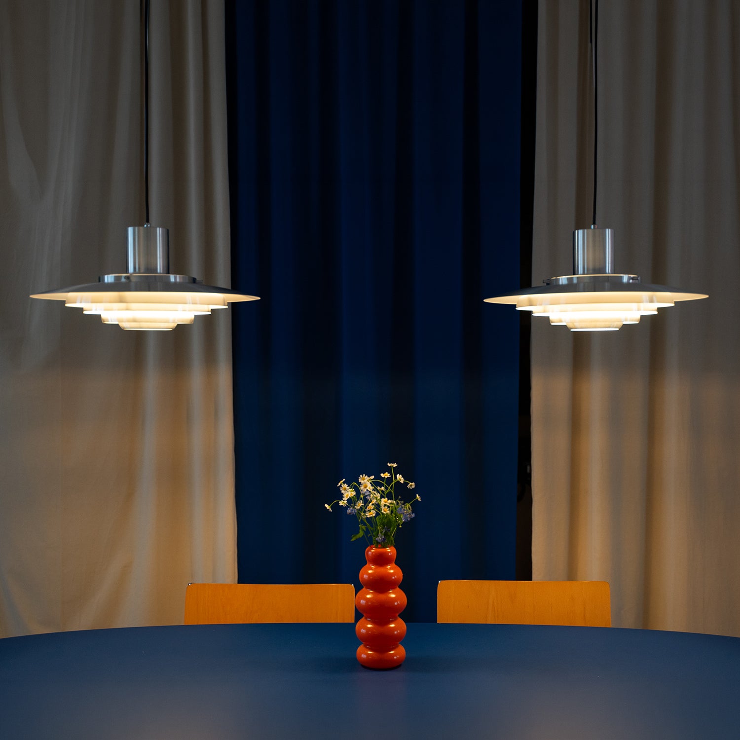 UFO Hängelampe von GLOW UP STUDIO – schwebend über Designer Küchentisch und oranger Vase
