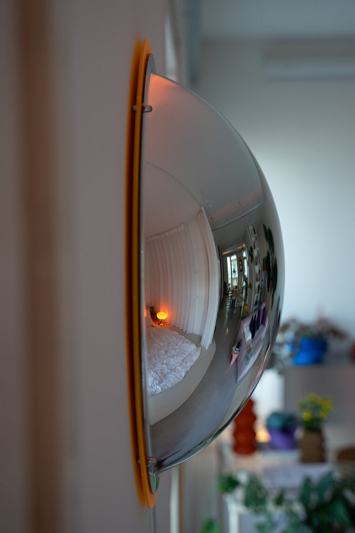 BUBBLE Spiegellampe Seitenansicht – gewölbte Acrylkuppel an Wand, Wohnraum-Deko im Hintergrund