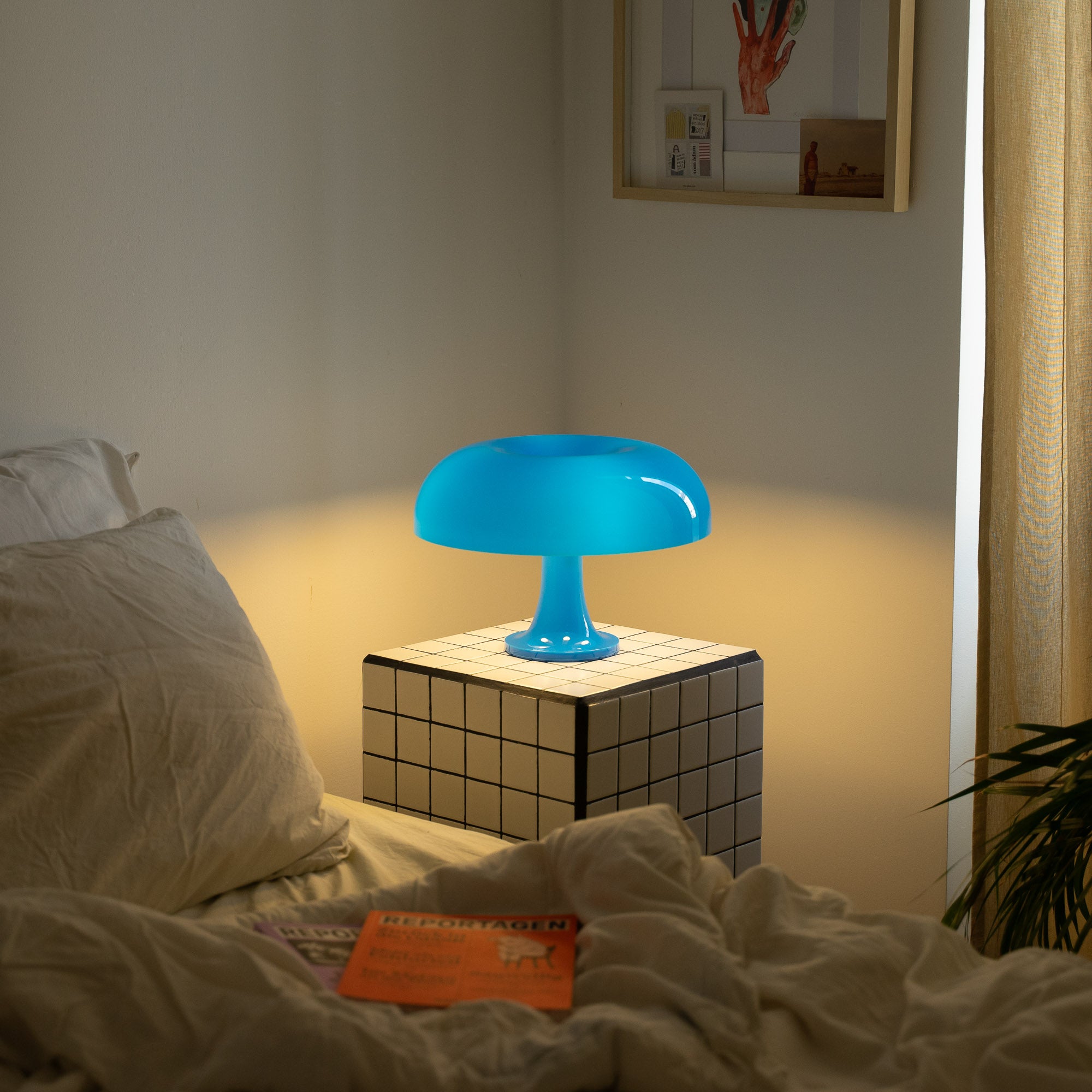 Die blaue Pilzlampe strahlt weiches Licht aus und schafft eine beruhigende Atmosphäre. Perfekt für ein stilvolles Wohn- oder Schlafzimmer. Minimalistisches Ambiente mit warmem Kontrast.