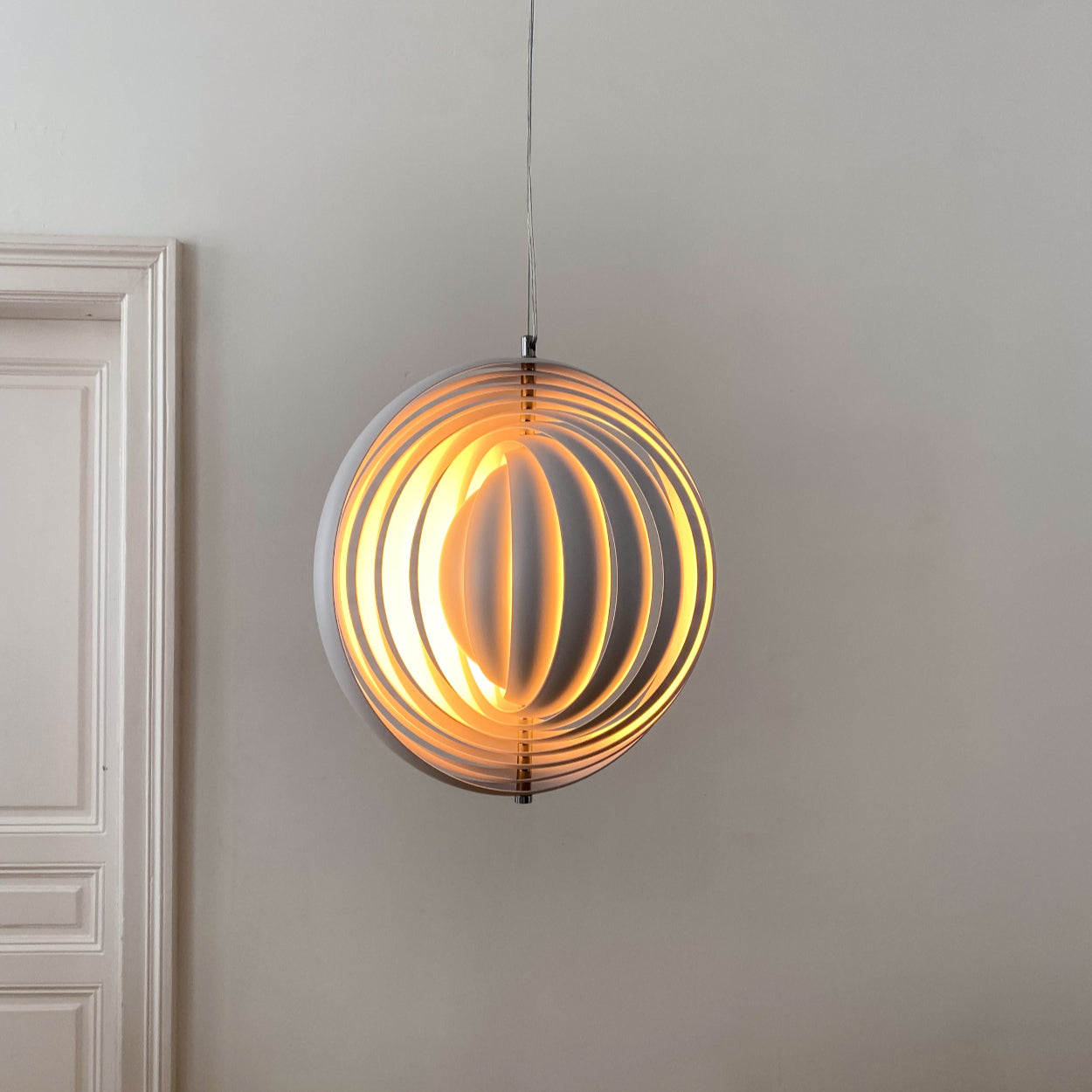 Moderne skulpturale Pendelleuchte in Weiß mit symmetrischen Lamellen, die ein warmes Licht ausstrahlen. Perfekt für Esszimmer oder Wohnzimmer im Mid-Century- und Bauhaus-Stil.