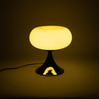 Die Lampe mit glänzendem Chromfuß strahlt warmes, diffuses Licht aus und schafft eine gemütliche Atmosphäre. Ihr ikonisches Mid-Century-Design erinnert an die 60er- und 70er-Jahre.