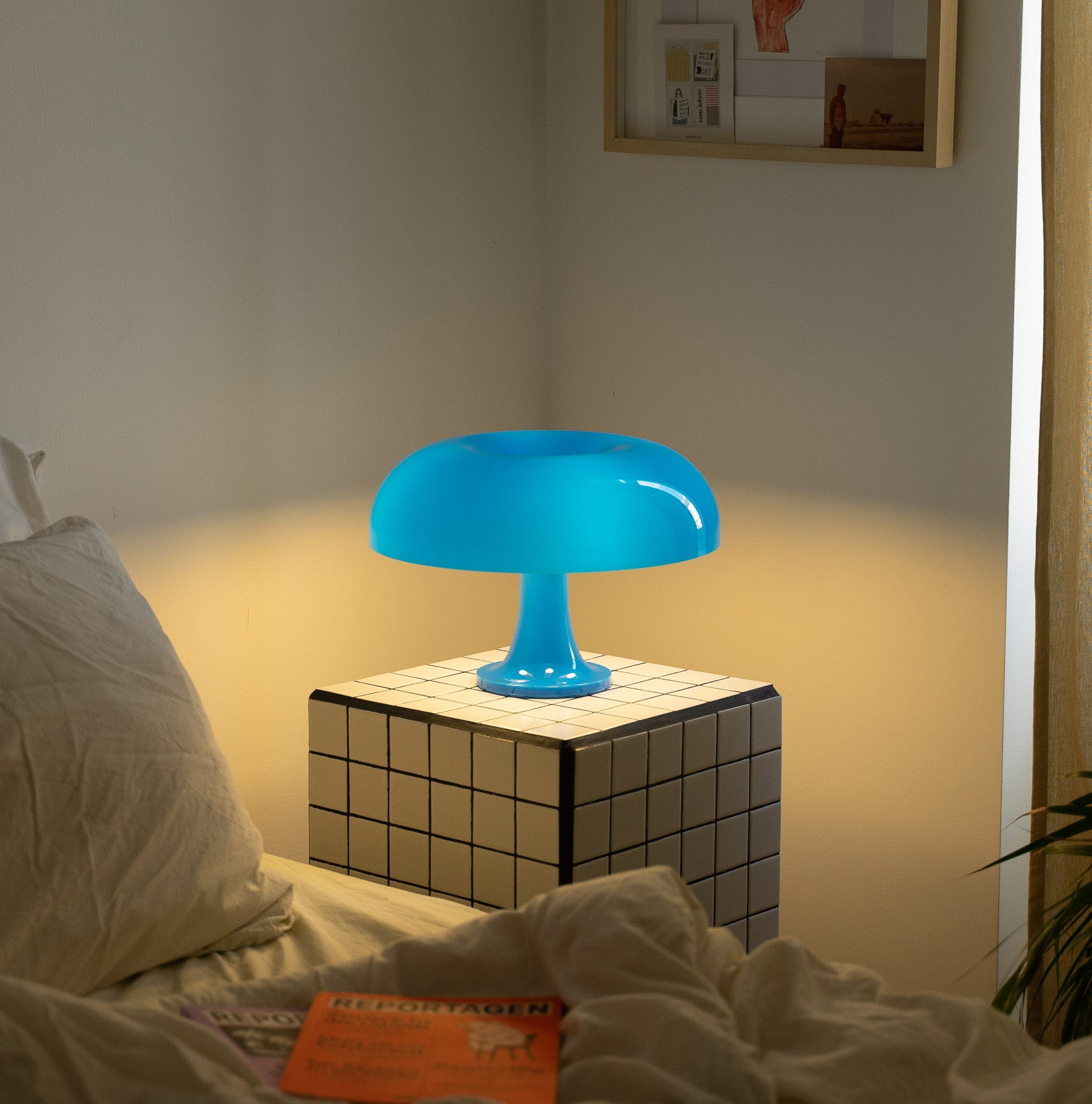 Die blaue Pilzlampe strahlt weiches Licht aus und schafft eine beruhigende Atmosphäre. Perfekt für ein stilvolles Wohn- oder Schlafzimmer. Minimalistisches Ambiente mit warmem Kontrast.