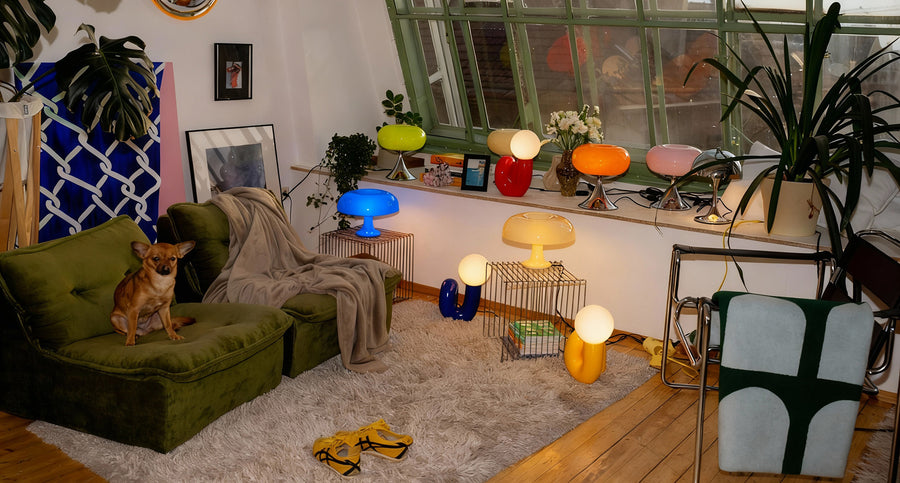 Wohnzimmer im 60er Retro Stil mit mehreren farbigen Snake und Donut Lampen von GLOW UP STUDIO, grünem Sofa, großem Altbaufenster und stilvoller Einrichtung